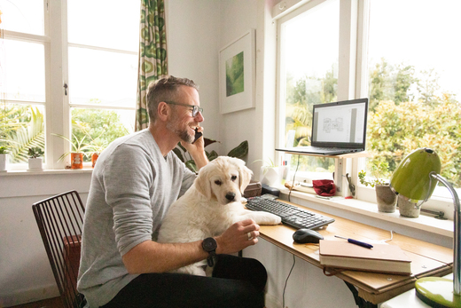 Man with dog talking to financial advisor on phone
